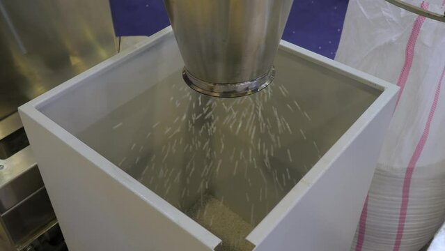 Waste plastic recycling machine: propylene or polyethylene pellets - recycled plastic granules falling in metal container. Environmental protection, separation, automated technology concept