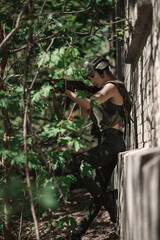 Military girl in uniform near a stone wall during the day
