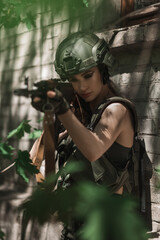 Fototapeta premium Military girl in uniform near a stone wall during the day