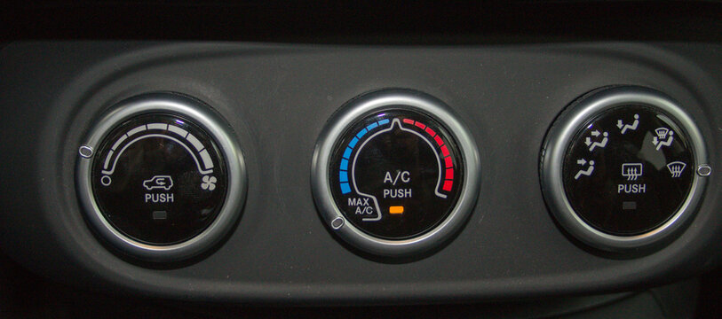 Image of the button to turn on the air conditioning of a car. Reference to the increase in fuel consumption by keeping it on. Expensive fuel