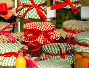 Fototapeta na wymiar Jars with homemade jam or compote lined with fabric and satin ribbons.