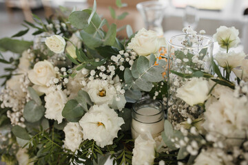 Decoration of the wedding table of the newlyweds, candles, gypsophila, eustoma, rose, eucalyptus