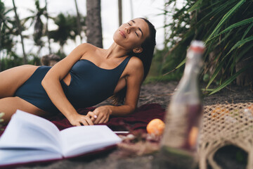 Carefree female with closed eyes dressed in swimwear enjoying free time for recreation at sandy beach - spending weekend for retreat time, Caucaisan hipster girl with literature best seller