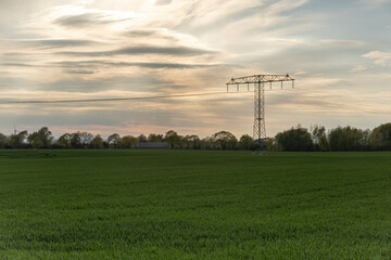 sunset sky over a green field with power pole