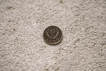 Soviet vintage collectible coin with the inscription USSR on the concrete floor.