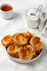 Homemade Yorkshire pudding on plate with tea. English traditional food. Grey background