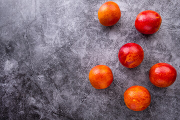 Fototapeta na wymiar Red oranges on grey background. Top view, copy space