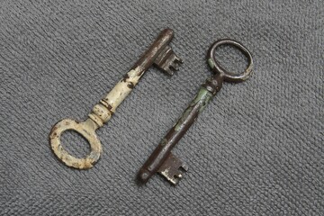Two old keys on a gray background.