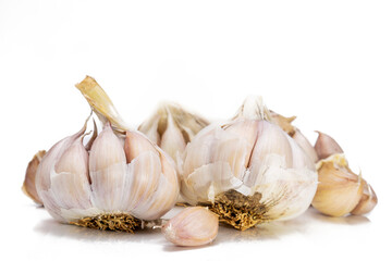 A lot of unpeeled garlic on a white background
