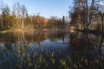 Morning view of a pond and a mist above the water.