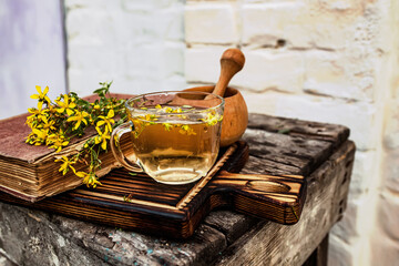 Fototapeta na wymiar St. John's wort. Hypericum plants yellow flower medicinal tea from dry herbs or a drink from tincture of medicinal plants crushed in a mortar. Ancient recipes 