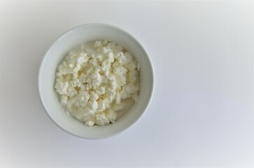 cottage cheese with cream in a white plate on a white background