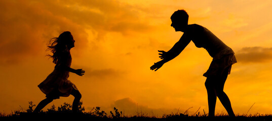 Silhouette of mother and daughter running to each other against sky in summer 