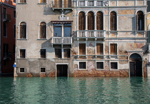 Venice, Italy, 18 October, 2020. Navigating the Canals on a passenger boat during the high tide period, very high sea level, the water is submerging steps and doorways and almost touching the windows.