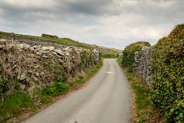 Maze of stone walls and small narrow road on Inisheer, Aran island, county Galway, Ireland. Popular travel area. Warm sunny day. Irish nature landscape. Vertical image