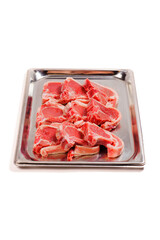 Nine fresh lamb chops on a metal tray. Meat industry product. Butcher craft. Fresh meat on a bone uncooked. White background.