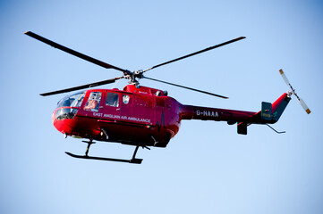 East Anglian Air Ambulance red helicopter flys over Cambridge