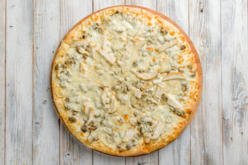 Pizza with chicken and mushrooms with creamy sauce and cheese top view on white wooden table