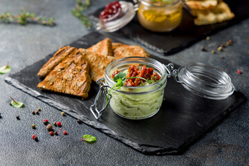 Avocado mousse with dried tomatoes with fried bread on dark stone plate