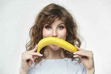 portrait of a beautiful girl holding a banana in her hands