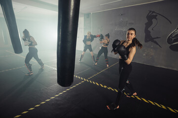 Boxer woman. Boxing fitness woman smiling happy wearing black boxing gloves. Portrait of sporty fit Asian model of boxing gym