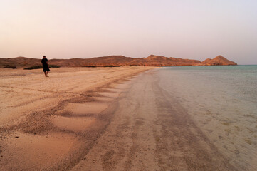 Fototapeta na wymiar Spiaggia con persona che cammina, isola di Zabargard
