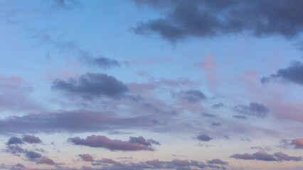 Ciel. Petits nuages roses, violets et gris au coucher du soleil au printemps