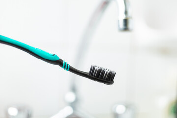 black tooth brush in a bathroom setting closeup 