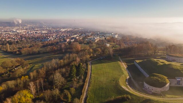 Fort Oberer Kuhberg and Ulm city on sunny golden morning low clouds time lapse