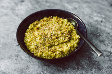vegan zucchini and basil pesto risotto with cashew parmesan topping, healthy plant-based food