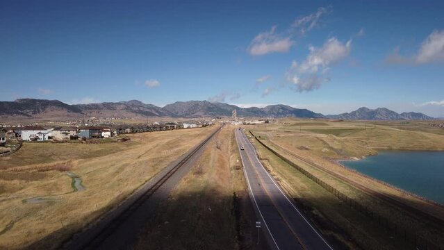 Train tracks and road leading from Rocky Flats to the foothills of the Rocky Mountains in Colorado, aerial