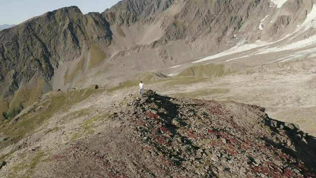 aerial landscape of Harding Icefield Kenai mountains in Alaska national park usa, trekker standing alone at the top of the crest rock formation in wilderness