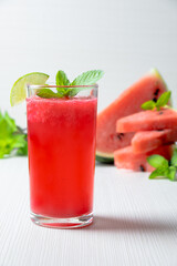watermelon juice smootie with lemon sliced and mint on white wood texture.studio lighting. home made watermelon concept.
