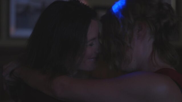 close up of Two women dancing intimately in bar and kissing