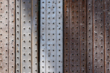 light and shadow on metal wall. steel with holes background and texture.