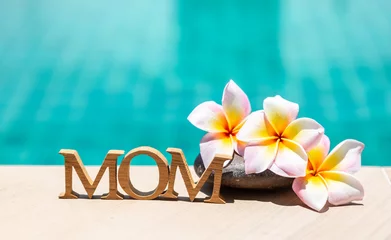 Keuken spatwand met foto Happy Mother's day in tropical concept, mom wooden alphabet with plumeria flower over blue water background © sirirak