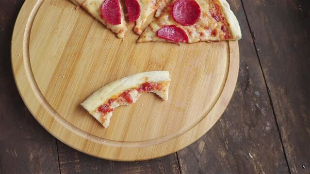 man take a pepperoni pizza slice from round board