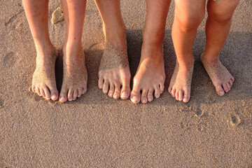 Three pairs of feet on the sand. Family on vacations.