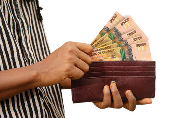 fair Female Hand Holding brown Purse With Ugandan shilling notes, hand removing money out of purse...