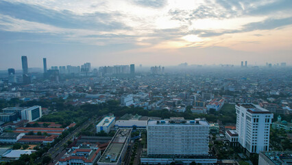 Aerial view of office buildings in Jakarta central business district and noise cloud when sunrise. Jakarta, Indonesia, May 6, 2022