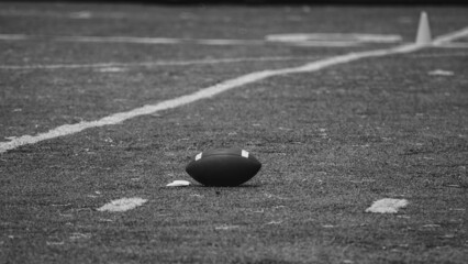 Balón de futbol americano en el campo en monocromo