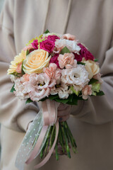 Bouquet for the bride in female hands. Flowers for the wedding. Peache and rose flowers. Gerbera, eustoma, roses.