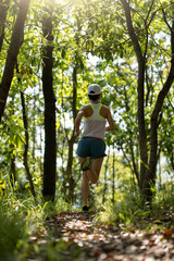 Woman runner running on forest trail