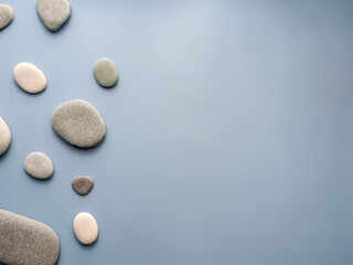 Flat spa stones (pebbles) on a blue background. View from above. Flat lay. Horizontally. Place for text. copy space