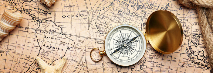 Vintage compass with sea shells on world map. Travel concept