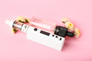 Modern vape mod, oil and flowers on pink background, closeup