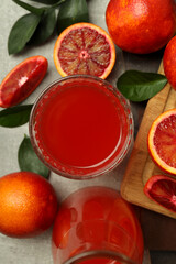 Concept of fresh drink with red orange juice on gray textured table