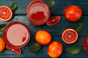 Concept of fresh drink with red orange juice on wooden table