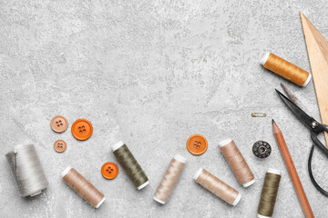 Sewing threads, buttons, scissors and ruler on grey background