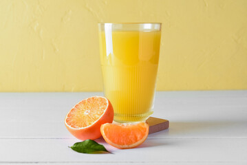 Glass of fresh tangerine juice on light table